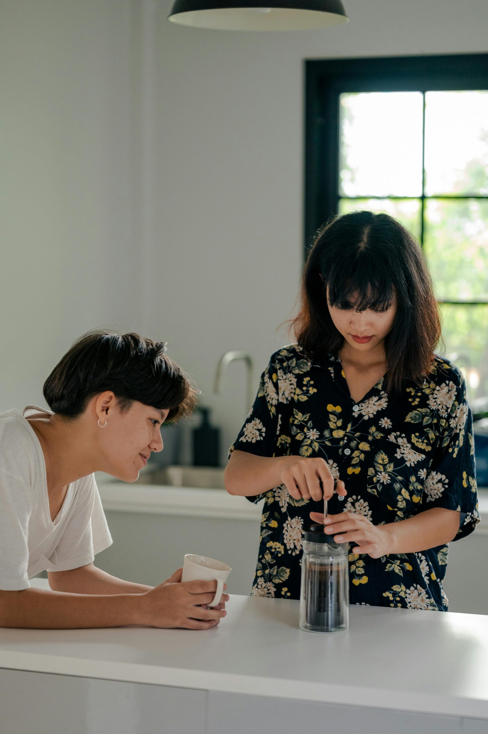 Two women making coffee together.