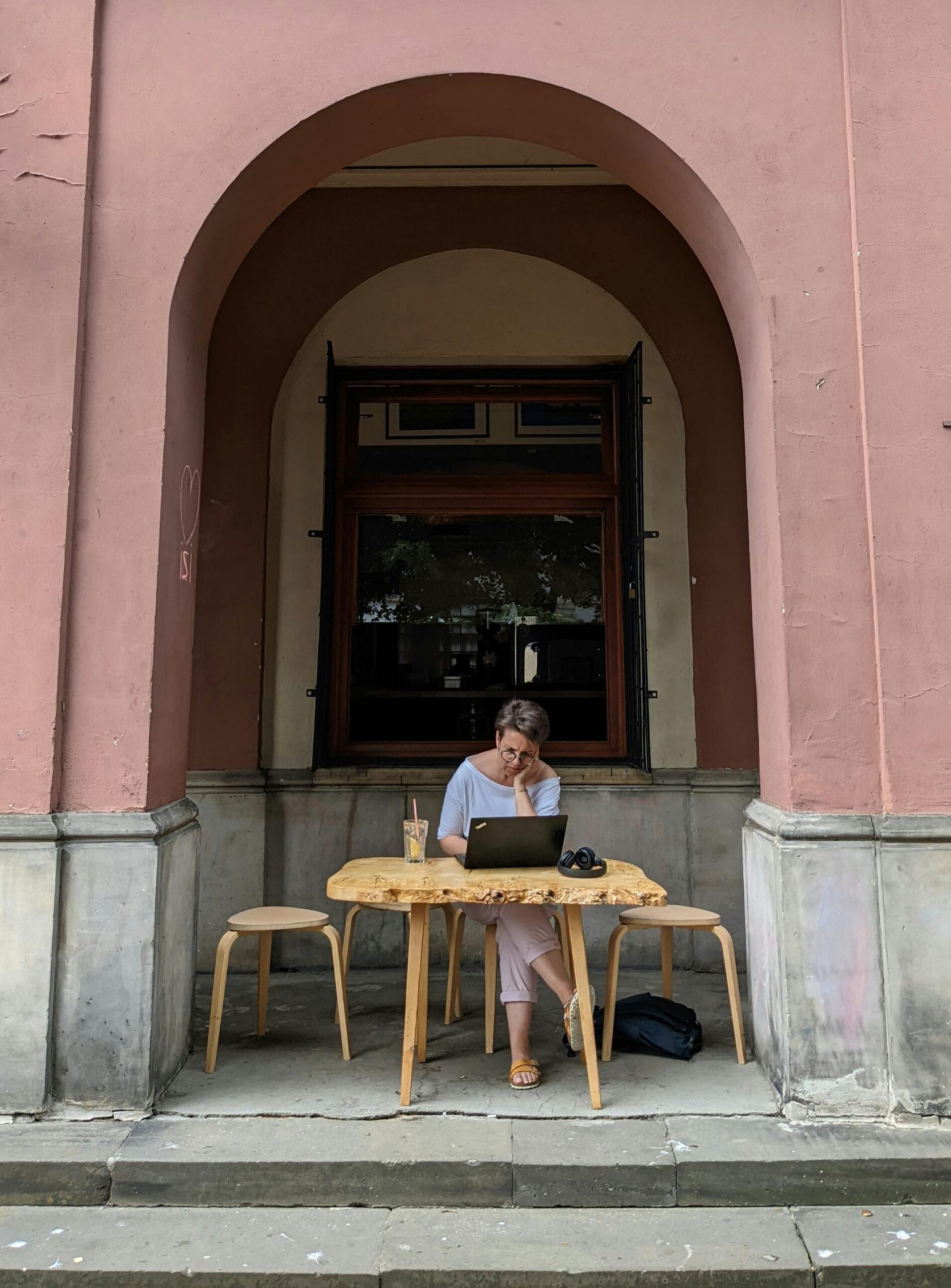 Woman working on a laptop at a restaurant outside