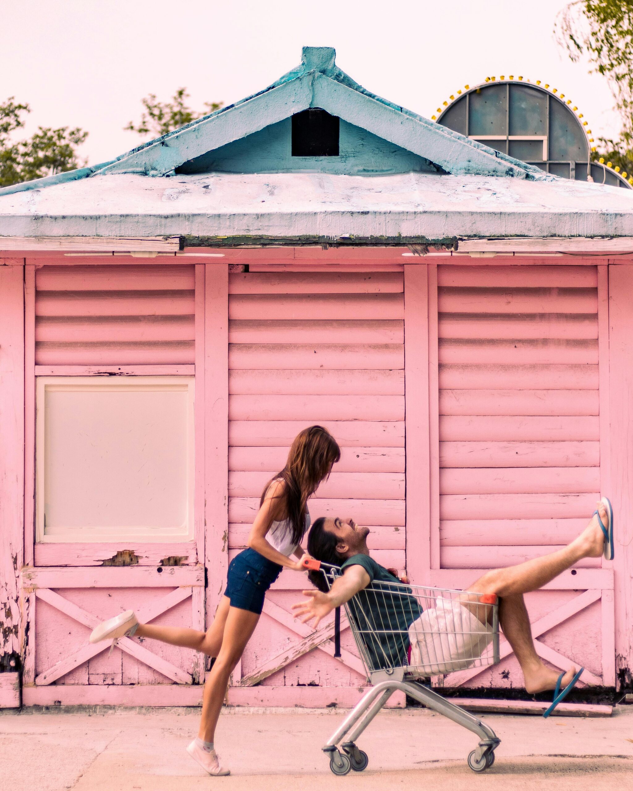 Woman pushing a man in a shopping cart