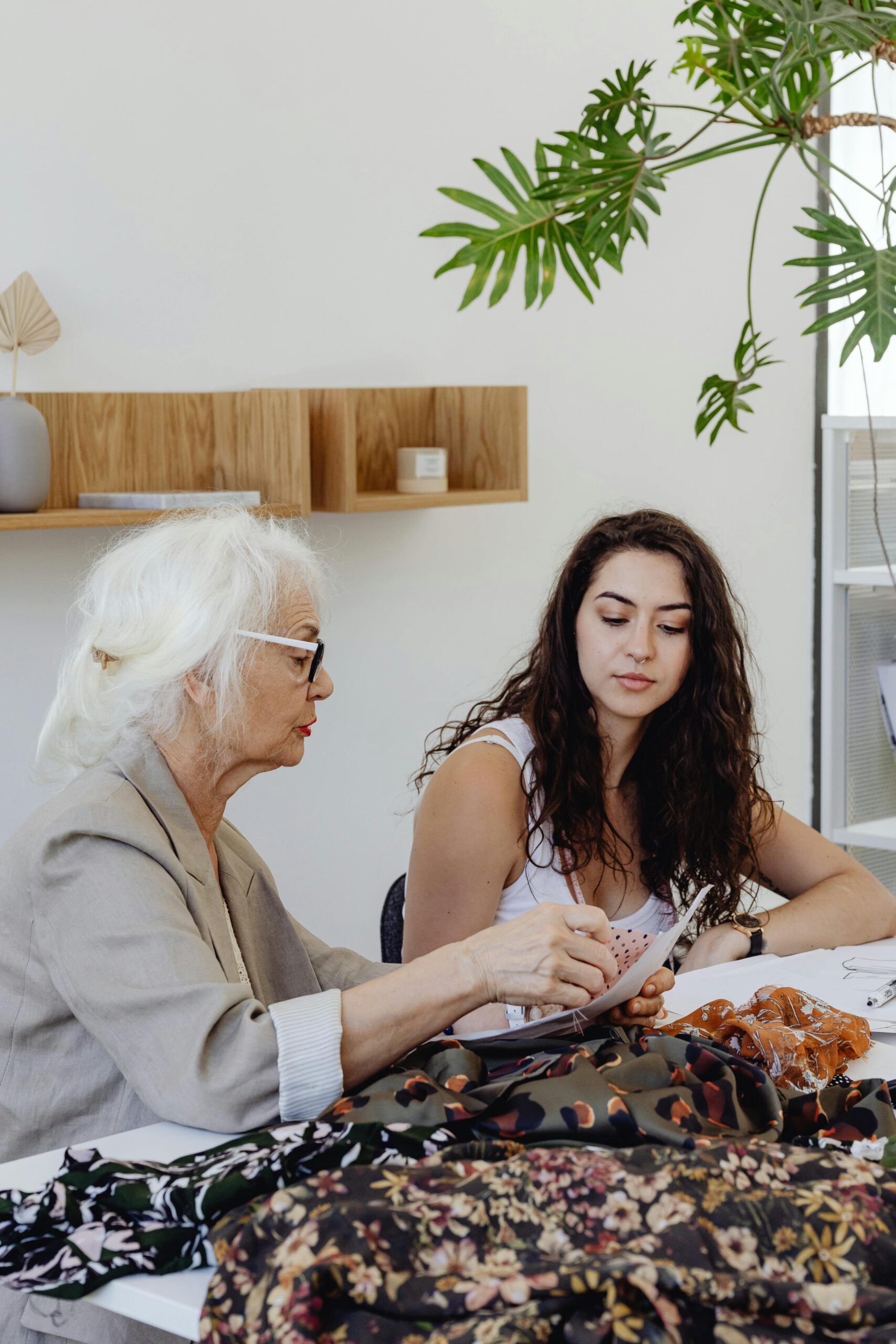 An older and youger woman working on a laptop