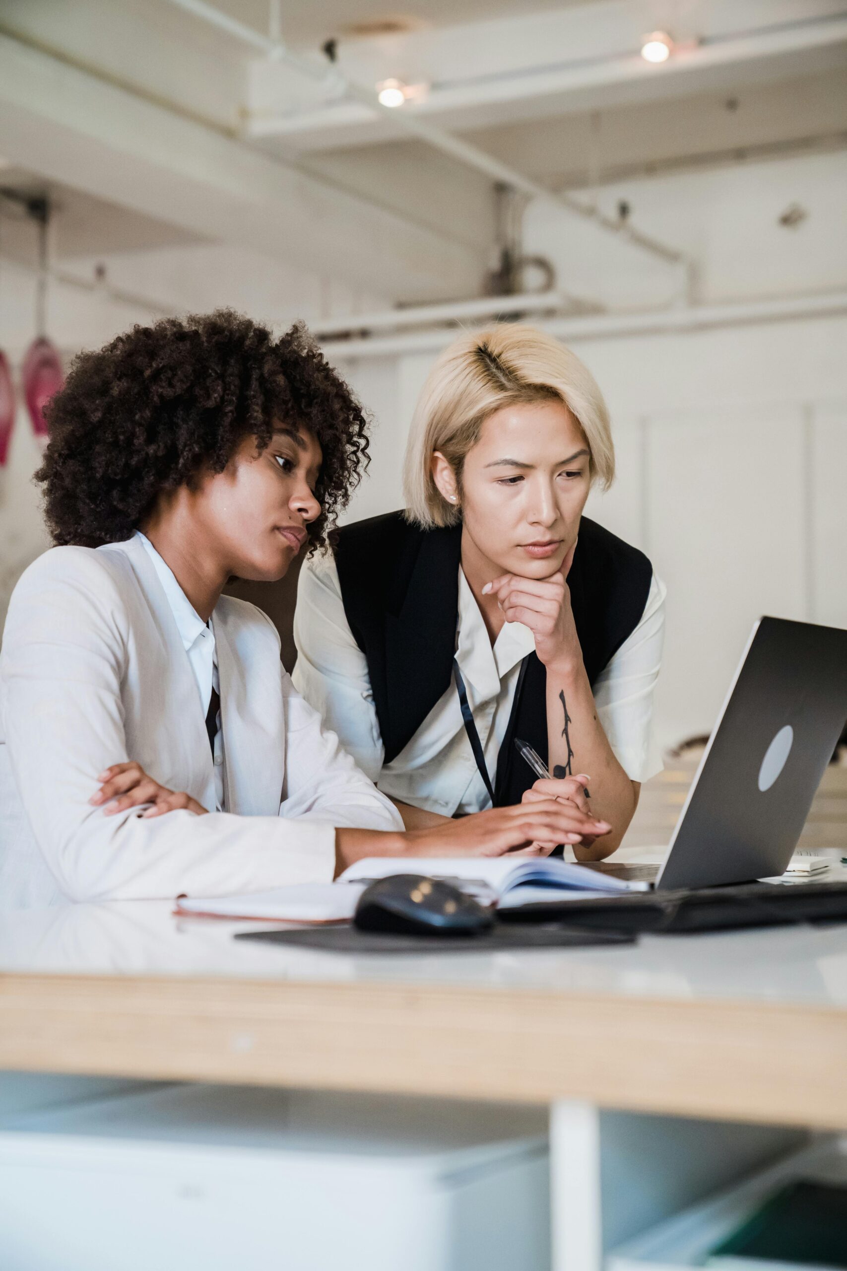 two women working over a laptop