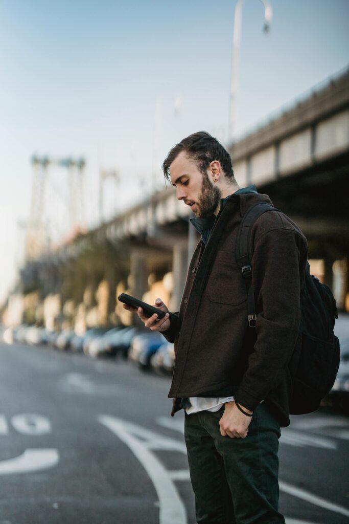 Man reading phone while walking on the street