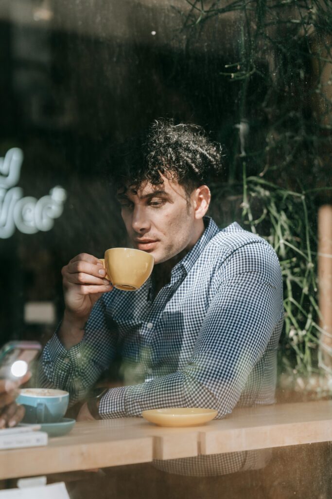 Man drinking from a yellow ceramic mug