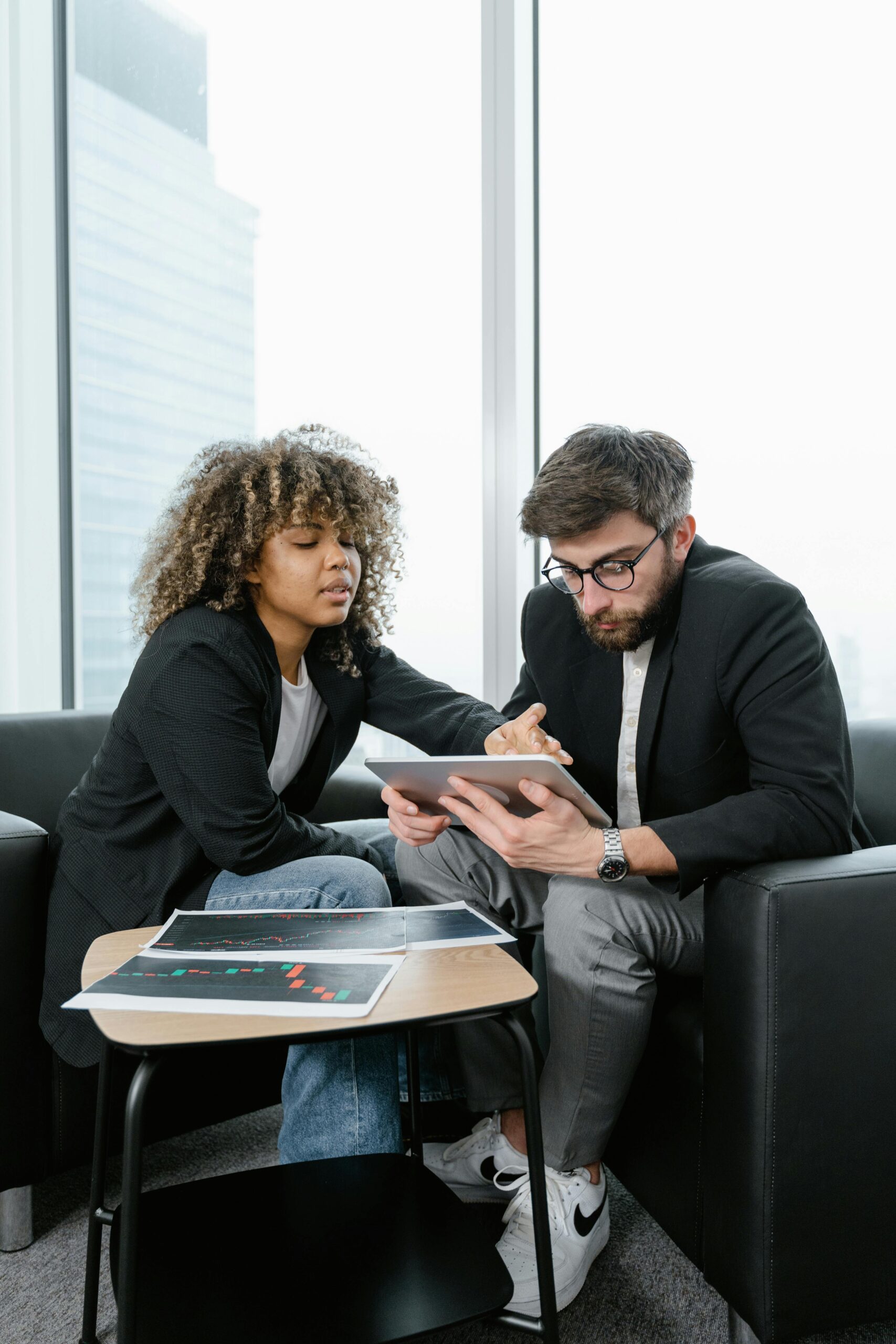 Man and woman sitting on black sofa discussing