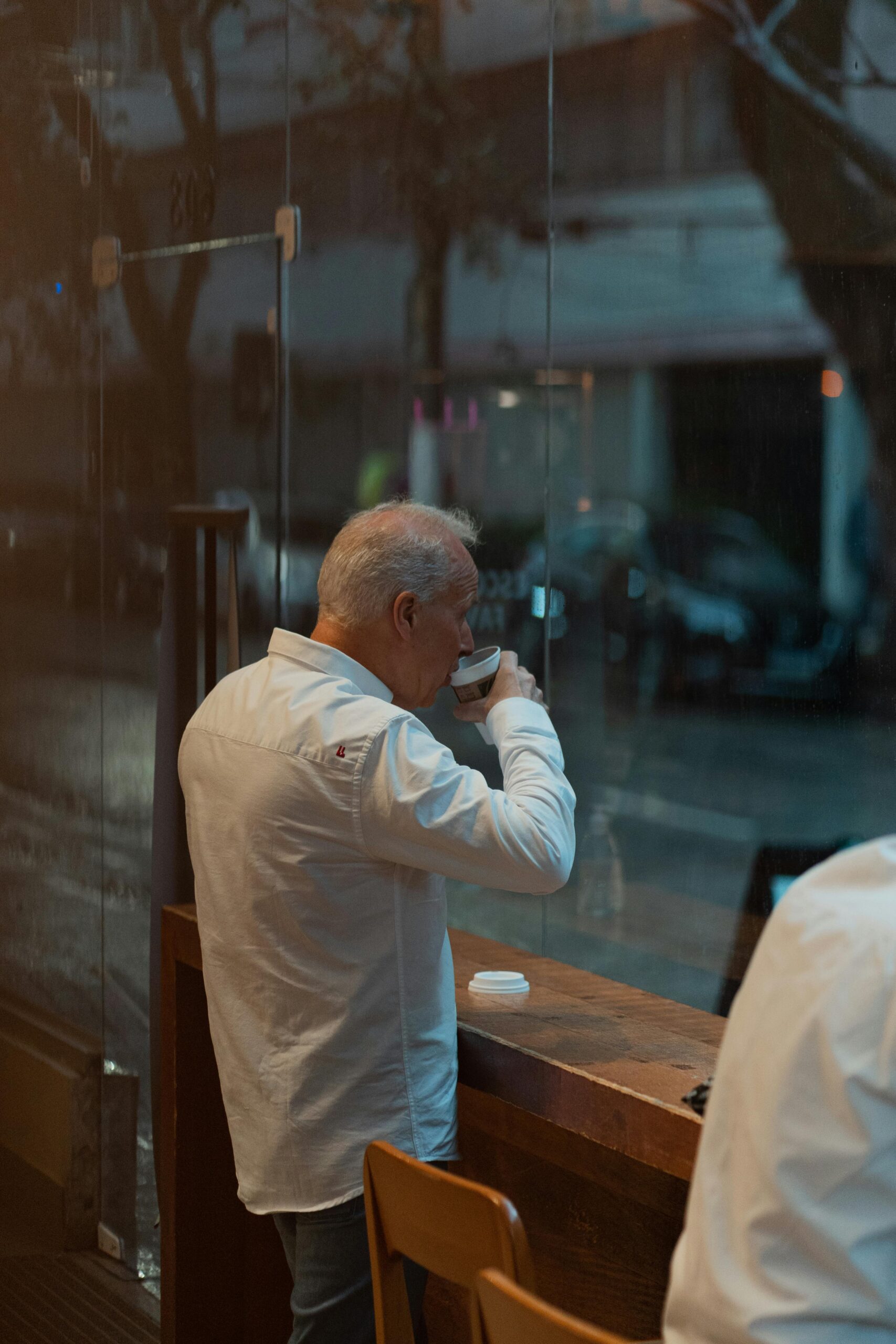 Man drinking coffee looking out window