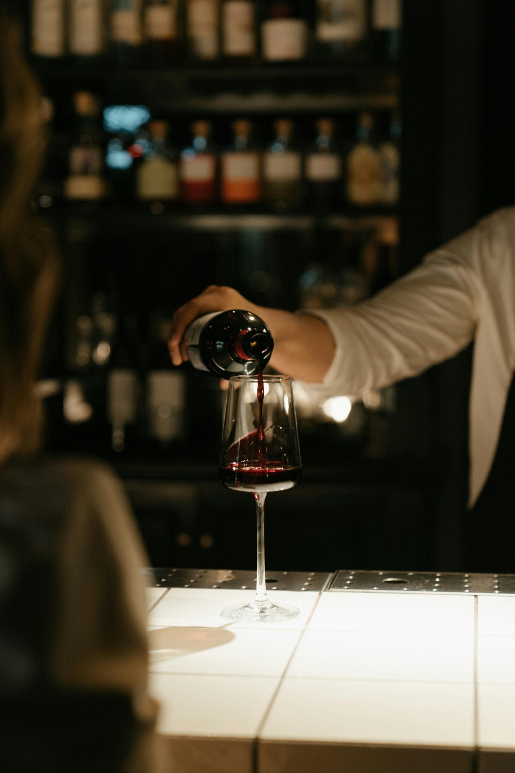 bartender pouring a glass of wine