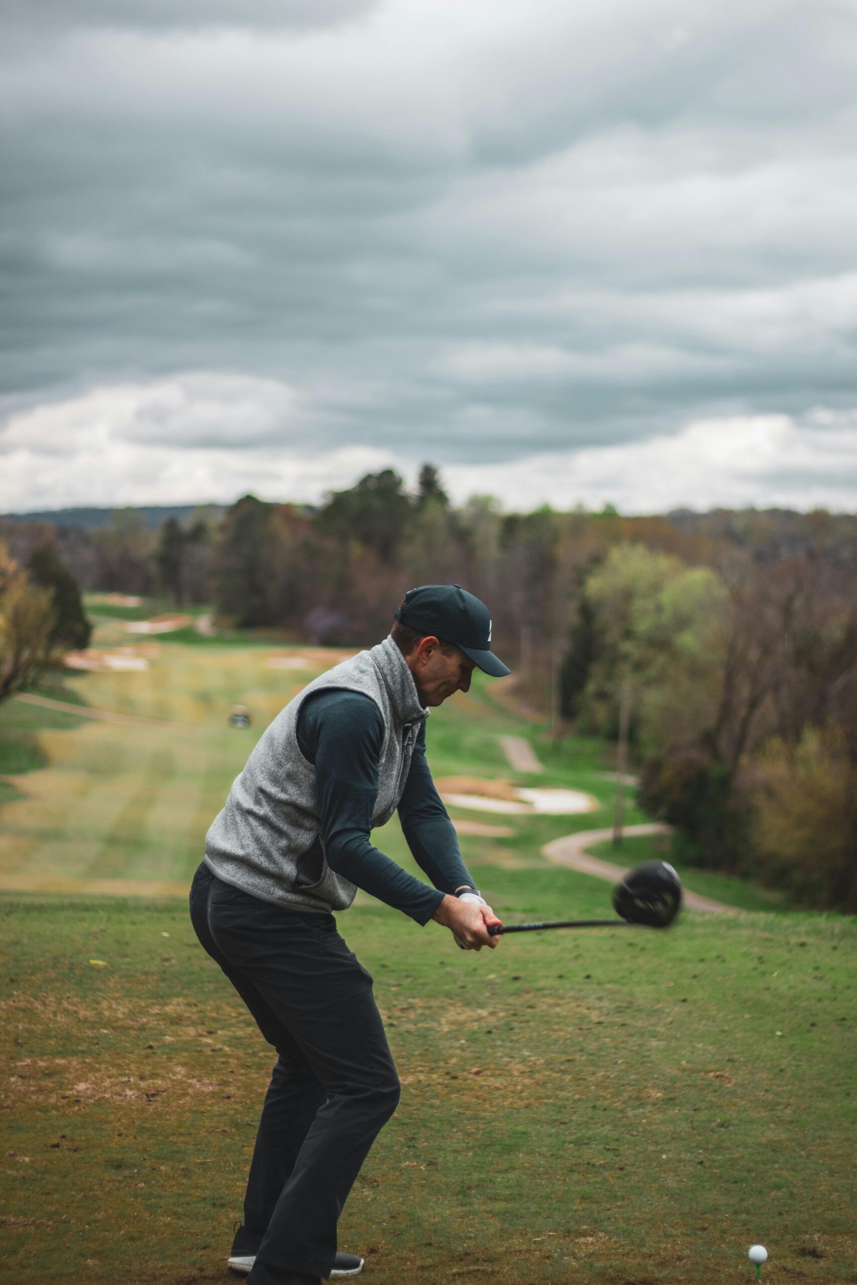 Man swinging golf club on golf course