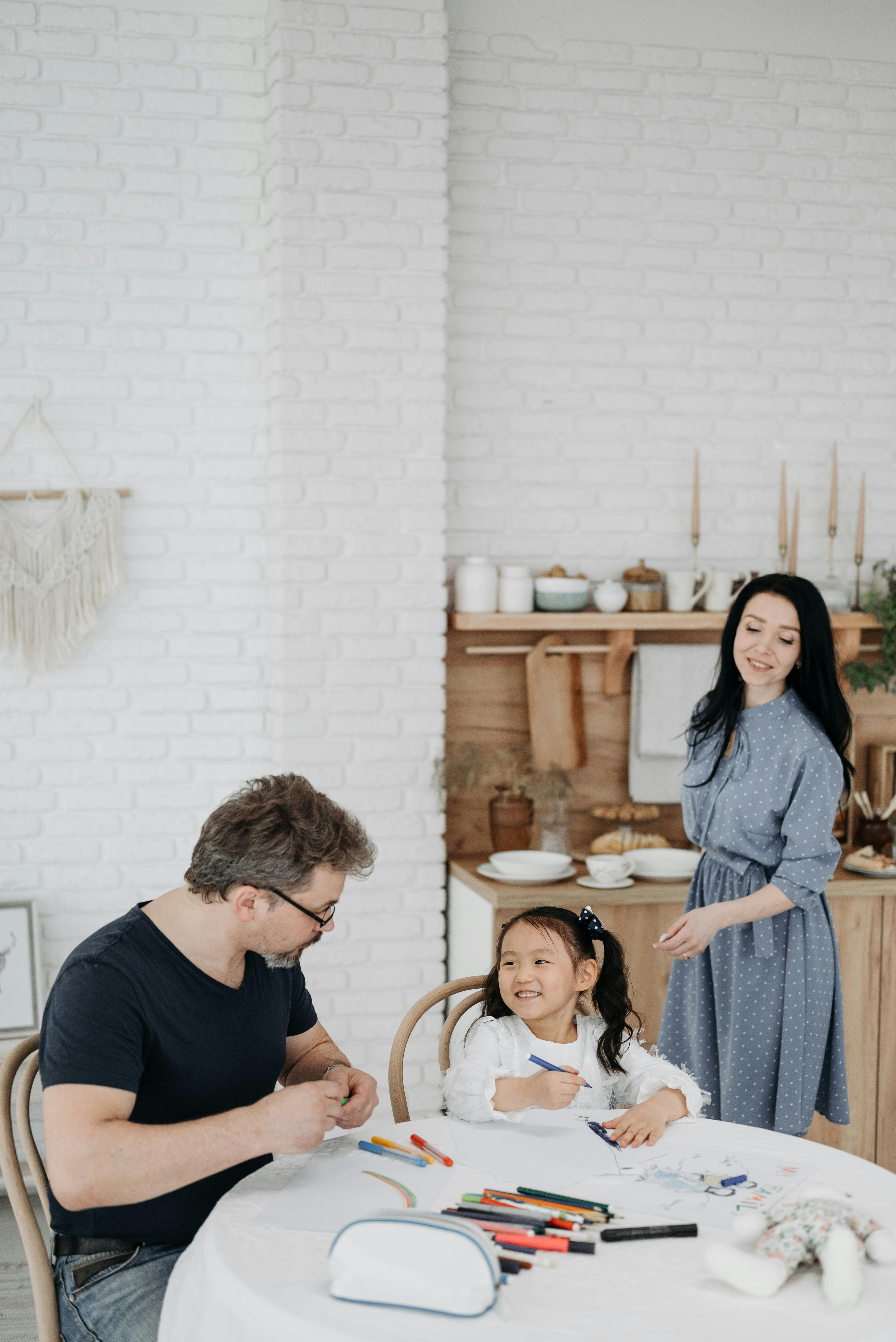mom in kitchen while dad helps daughter with homework