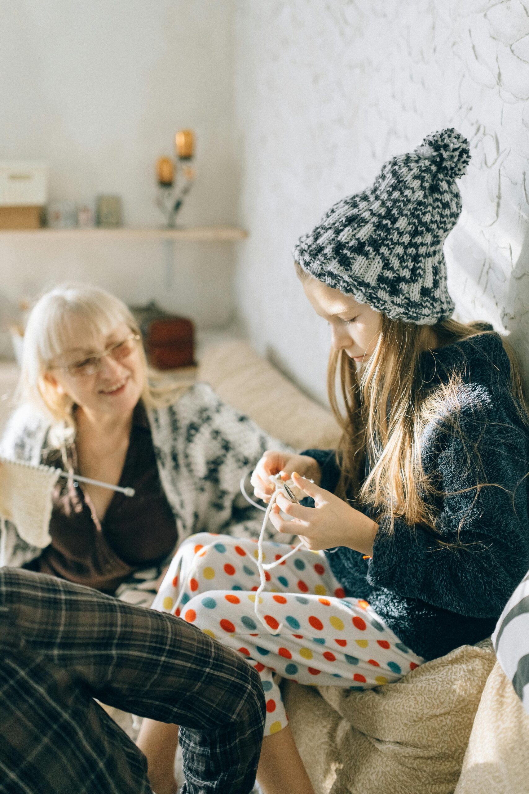Grandmother teaching granddaughter how to sew.