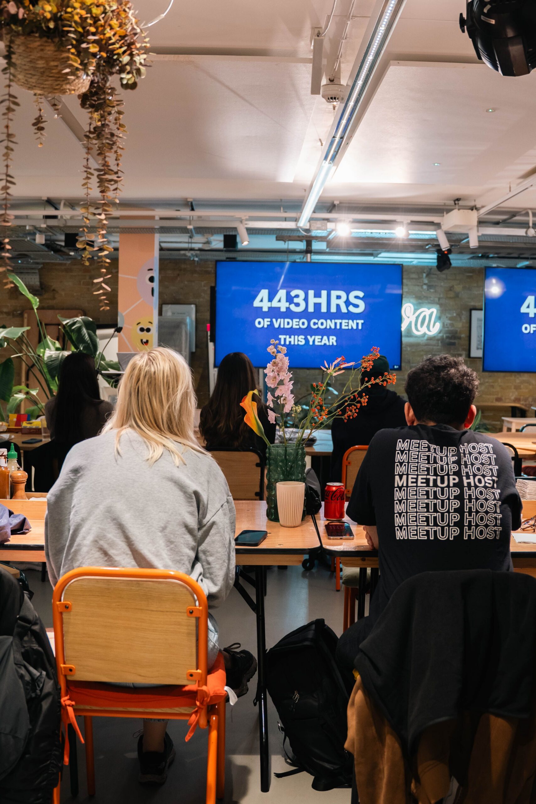 Interactive team meeting in a modern office discussing 443 hours of video content, fostering collaboration