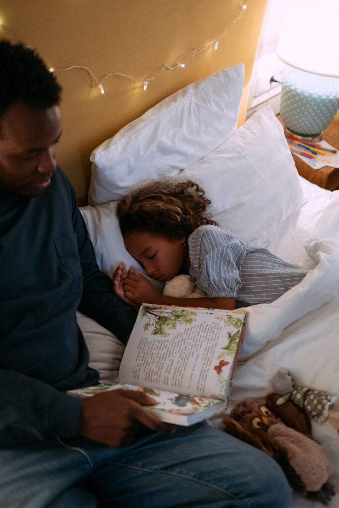 Father reading bedtime story to daughter